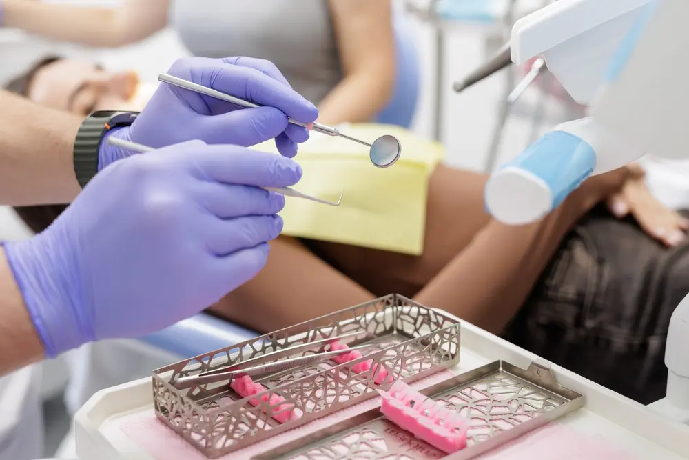 Dentist in purple gloves treating a patient during advanced prosthodontic care