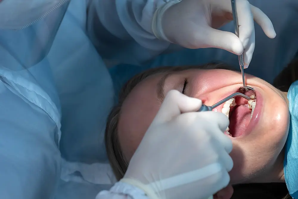 Dentist treating patient with dental tools during full mouth reconstruction care