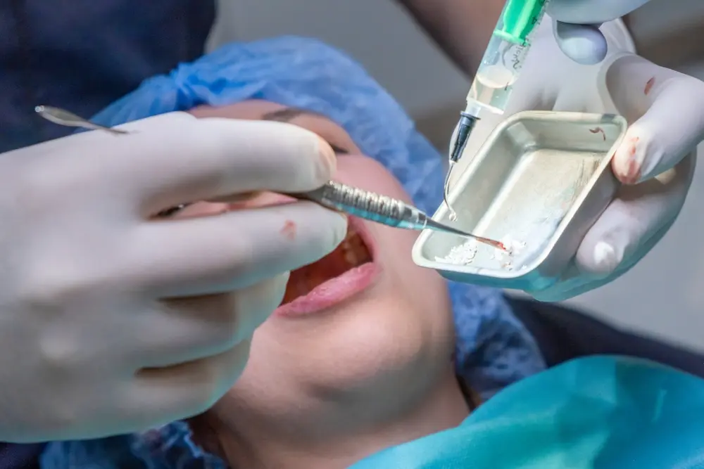 Dentist using dental tools during tooth extraction and bone graft evaluation